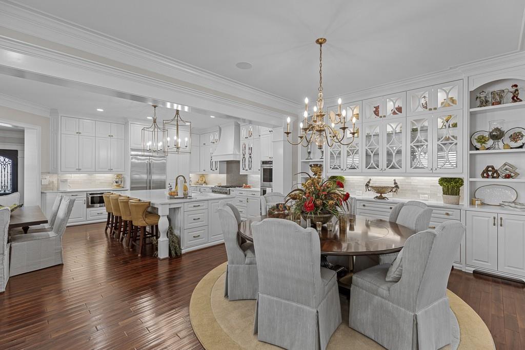 2794 Cork Street Hoschton, GA 30548 - Photo 17 of 51 a view of a dining room and livingroom with furniture wooden floor a chandelier