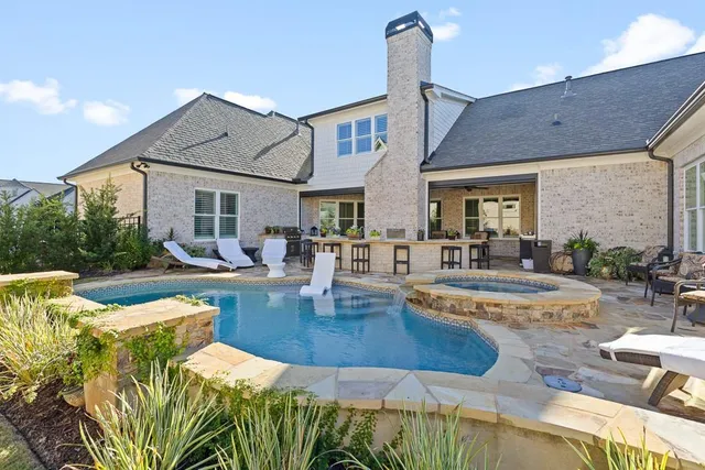 a view of a house with swimming pool and sitting area