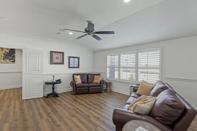 a living room with furniture and a wooden floor