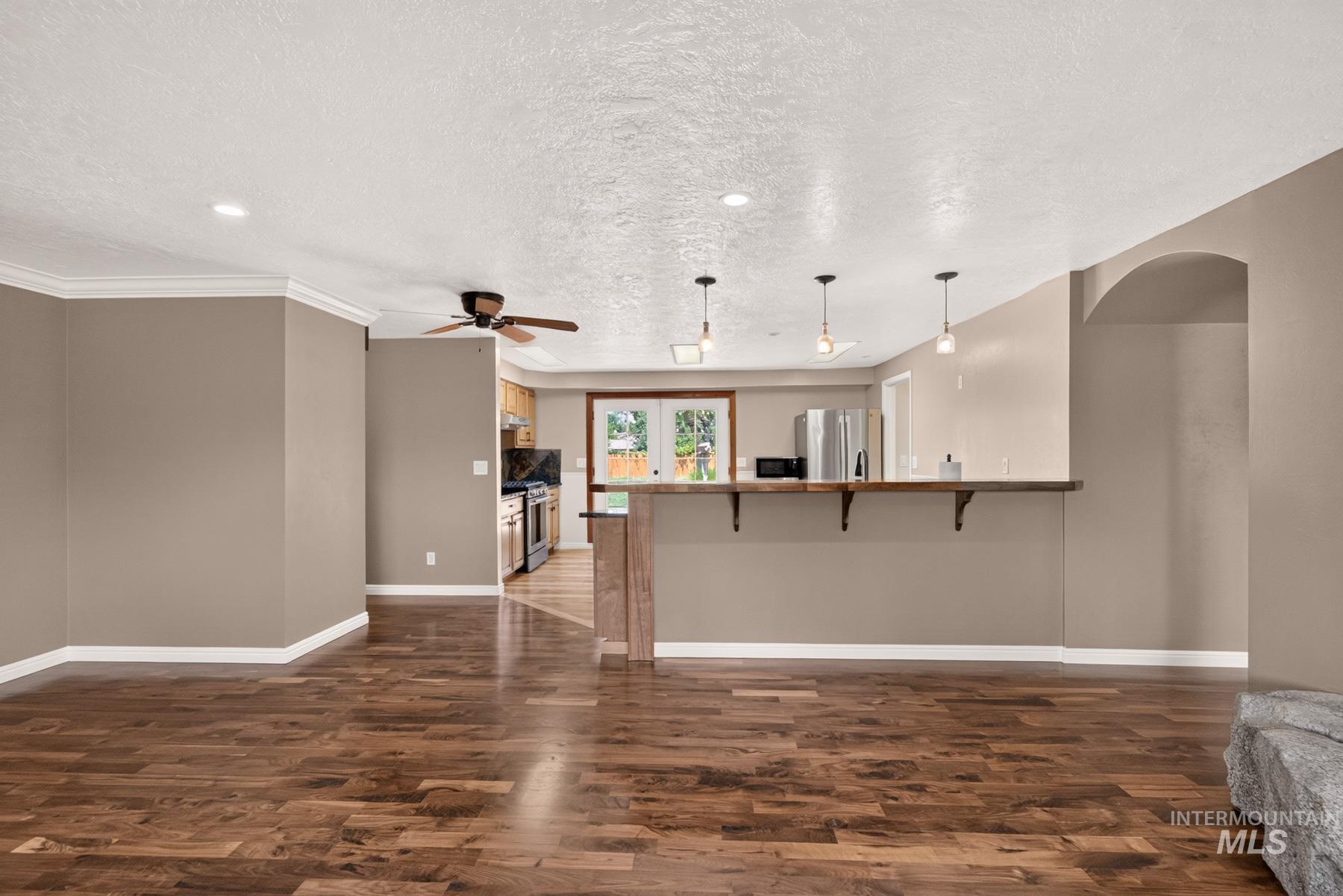 9622 Delaware Street Boise, ID 83709 - Photo 10 of 48 Open-concept living area featuring wood-finish flooring, recessed lighting, and crown molding