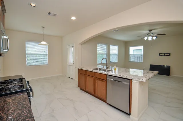 a large kitchen with granite countertop a stove and a sink