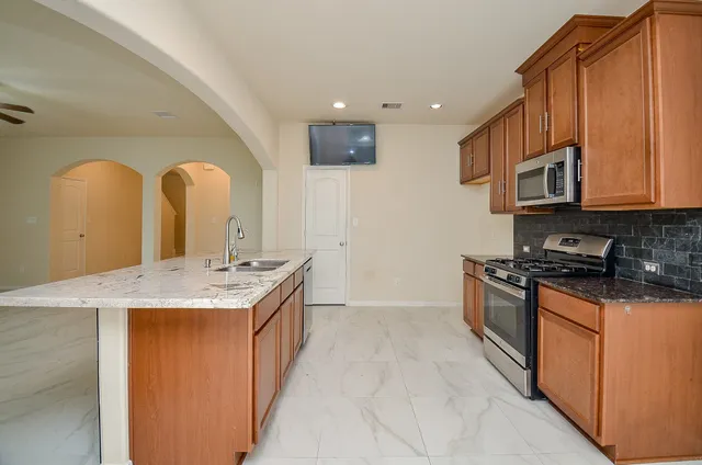 a kitchen with stainless steel appliances granite countertop a sink and a stove