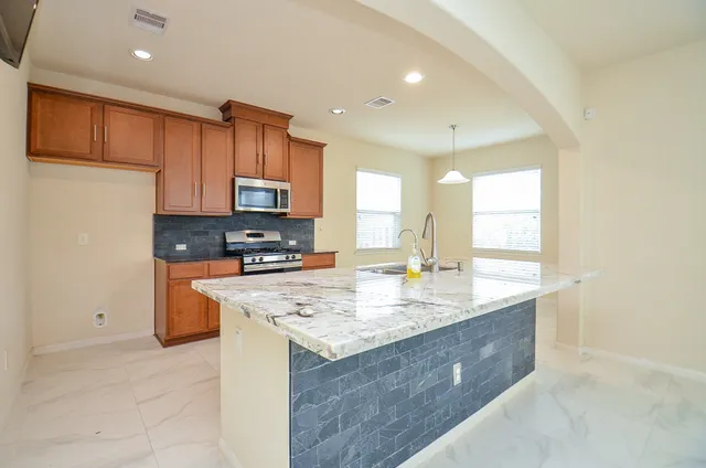 a kitchen with stainless steel appliances granite countertop a sink stove and refrigerator
