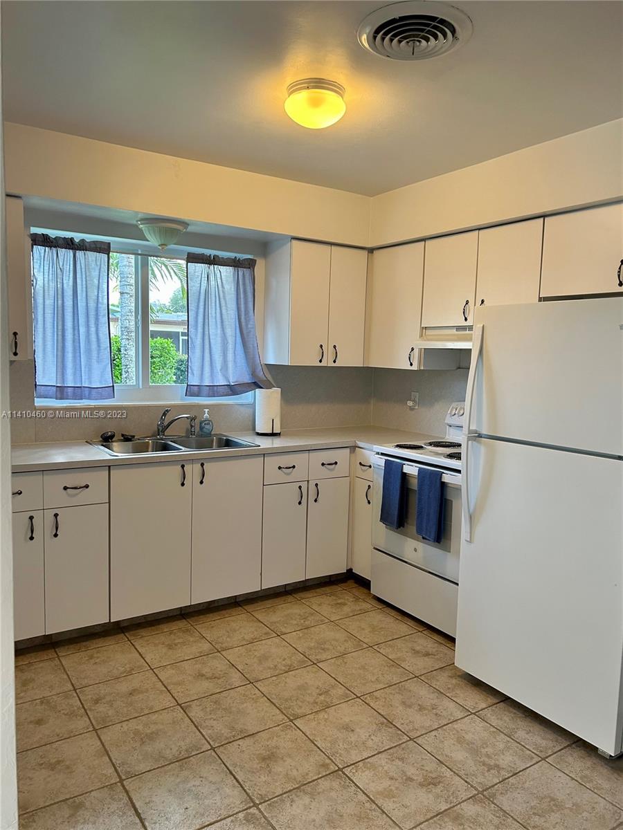 3790 Polk Street Hollywood, FL 33021 - Photo 13 of 23 a kitchen with cabinets and white appliances