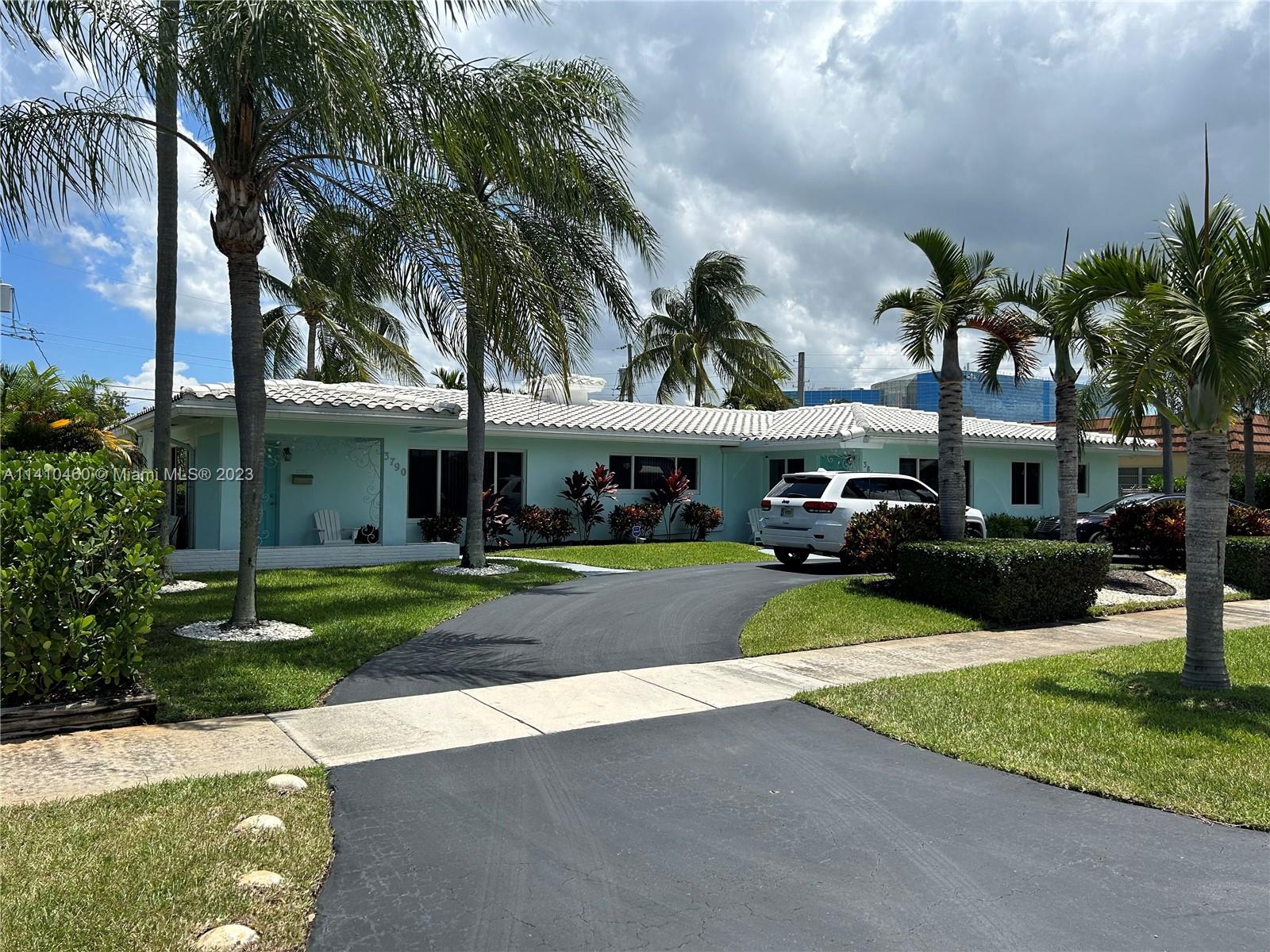 3790 Polk Street Hollywood, FL 33021 - Photo 2 of 23 a view of a car parked in front of a house with a yard