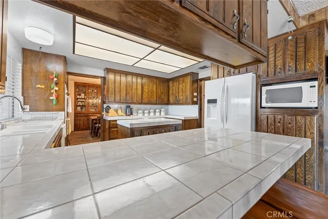 a bathroom with a granite countertop sink a toilet a mirror and shower