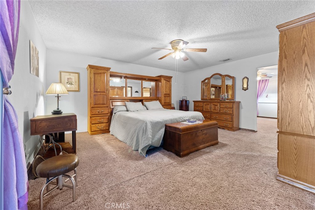 18200 Van Buren Boulevard Riverside, CA 92508 - Photo 29 of 56 a spacious bedroom with a bed and a chandelier