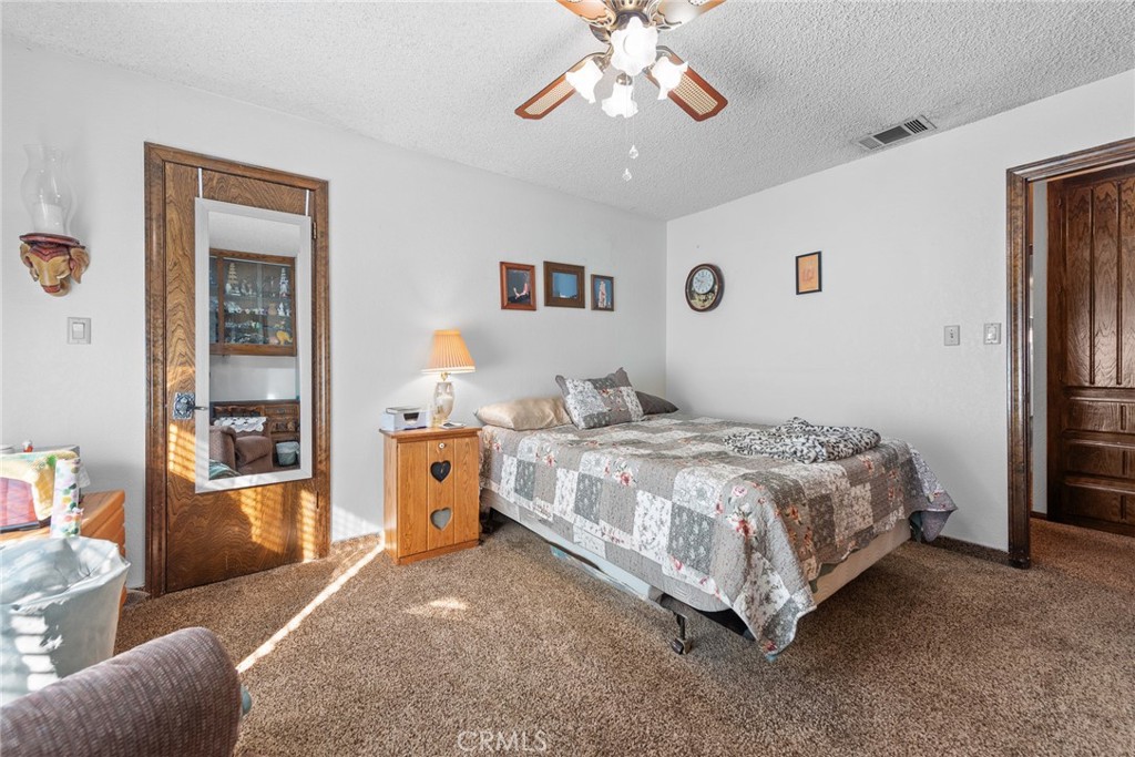 18200 Van Buren Boulevard Riverside, CA 92508 - Photo 9 of 56 a spacious bedroom with a bed and a chandelier