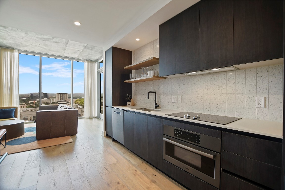 48 East Avenue, Unit 1701 Austin, TX 78701 - Photo 12 of 33 a kitchen with stainless steel appliances kitchen island granite countertop a stove a sink and a refrigerator