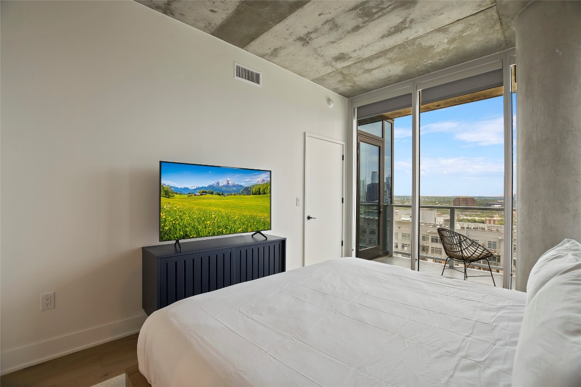 48 East Avenue, Unit 1701 Austin, TX 78701 - Photo 6 of 33 a bedroom with furniture and a flat screen tv