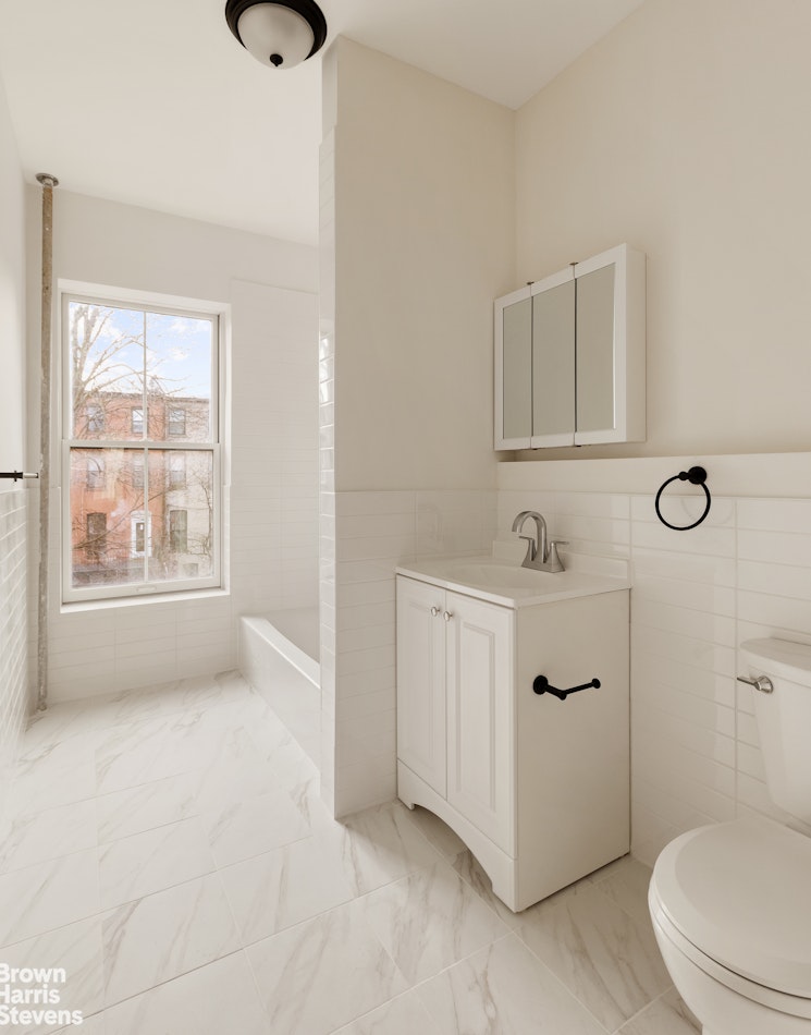 738 Madison Street Brooklyn, NY 11221 - Photo 10 of 14 a bathroom with a sink a toilet and window