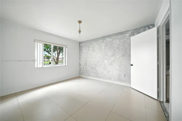 an empty room with windows and closet