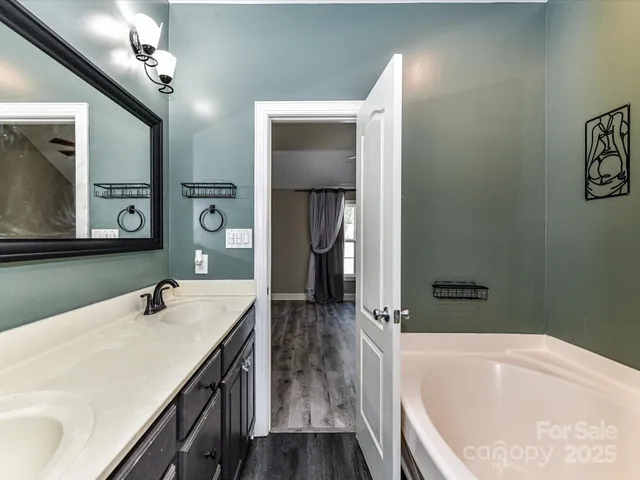 a bathroom with a tub sink and mirror