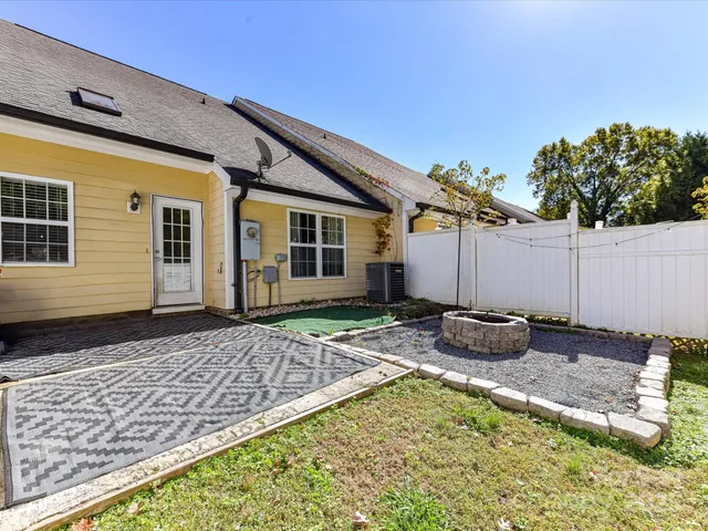 a view of house with backyard and sitting area