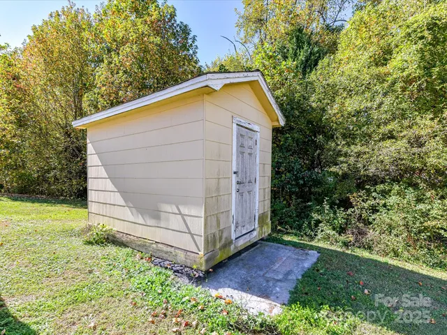a view of backyard of house with wooden fence