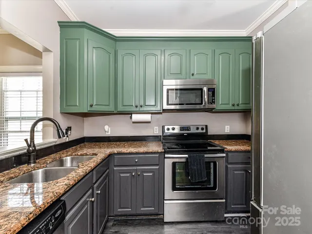 a kitchen with granite countertop a stove top oven microwave and cabinets
