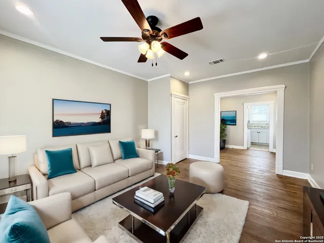 a living room with furniture and a wooden floor
