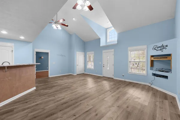 a view of an empty room with window and wooden floor