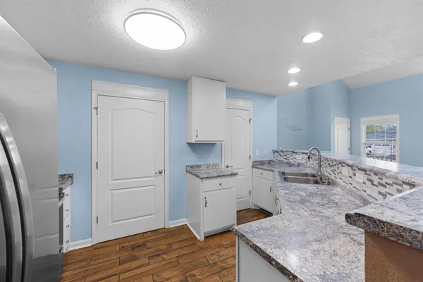 a kitchen with stainless steel appliances granite countertop a sink stove and refrigerator