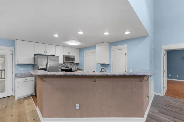 a kitchen with stainless steel appliances granite countertop a sink a stove and cabinets