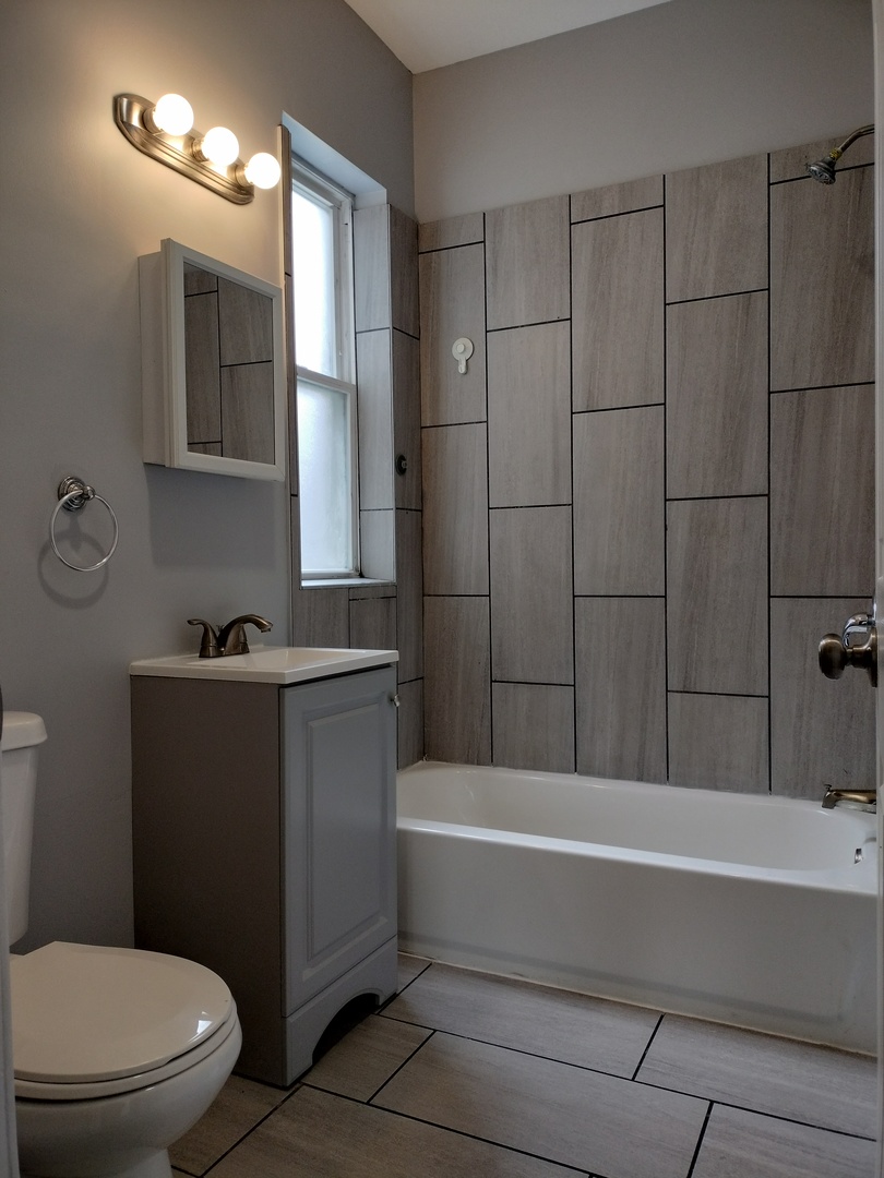 6601 South Green Street, Unit 8232 Chicago, IL 60621 - Photo 12 of 12 a bathroom with a toilet a sink and bathtub