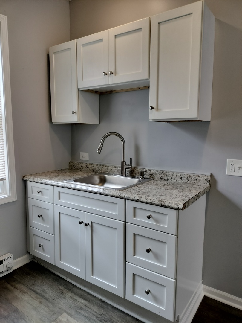 6601 South Green Street, Unit 8232 Chicago, IL 60621 - Photo 2 of 12 a kitchen with granite countertop white cabinets and a sink
