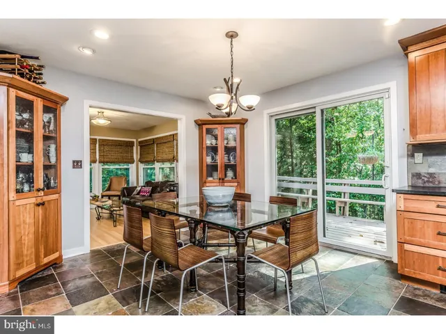 a dining room with wooden floor a chandelier a glass table and chairs