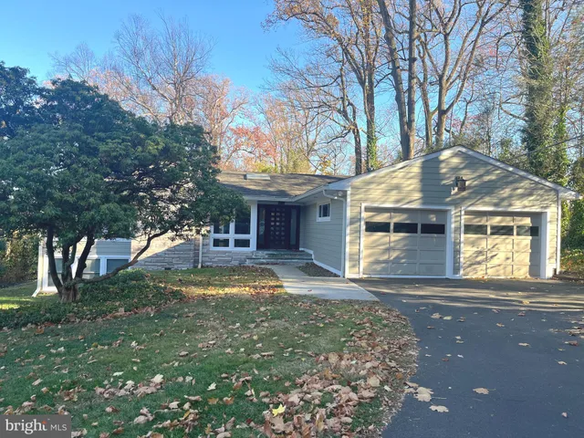 a view of a house with a yard and large tree