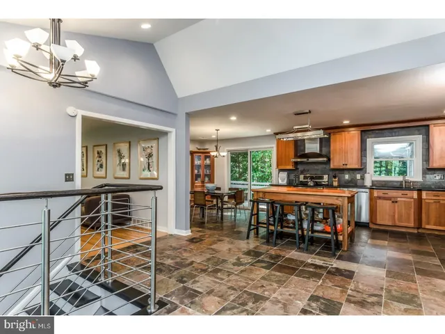 a living room with furniture a flat screen tv and kitchen view
