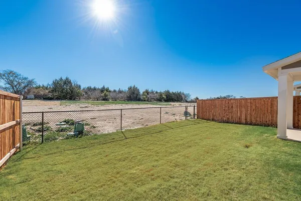 a view of a yard with wooden fence