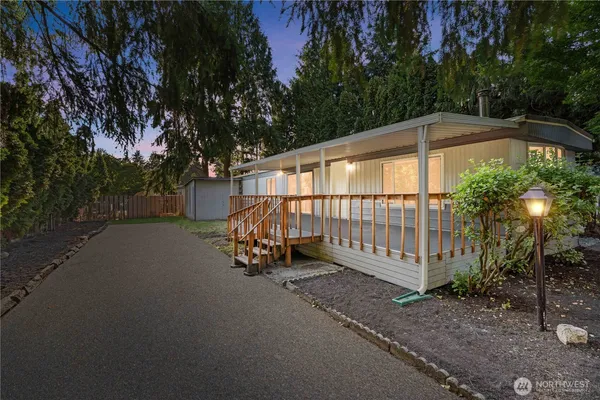 a side view of a house with a garden and trees