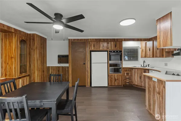 a kitchen with refrigerator a sink and chairs