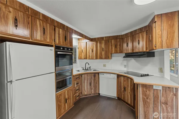 a kitchen with stainless steel appliances granite countertop a refrigerator a sink dishwasher a stove and a microwave oven on granite countertops