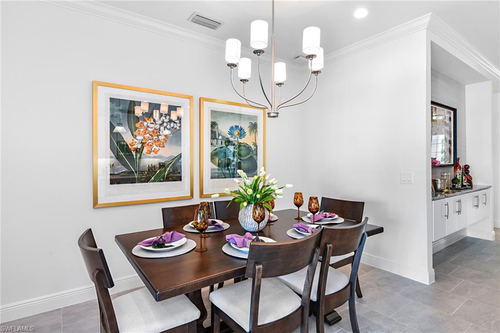 4621 Centaurus Circle Naples, FL 34120 - Photo 13 of 15 a view of a dining room with furniture a chandelier and wooden floor