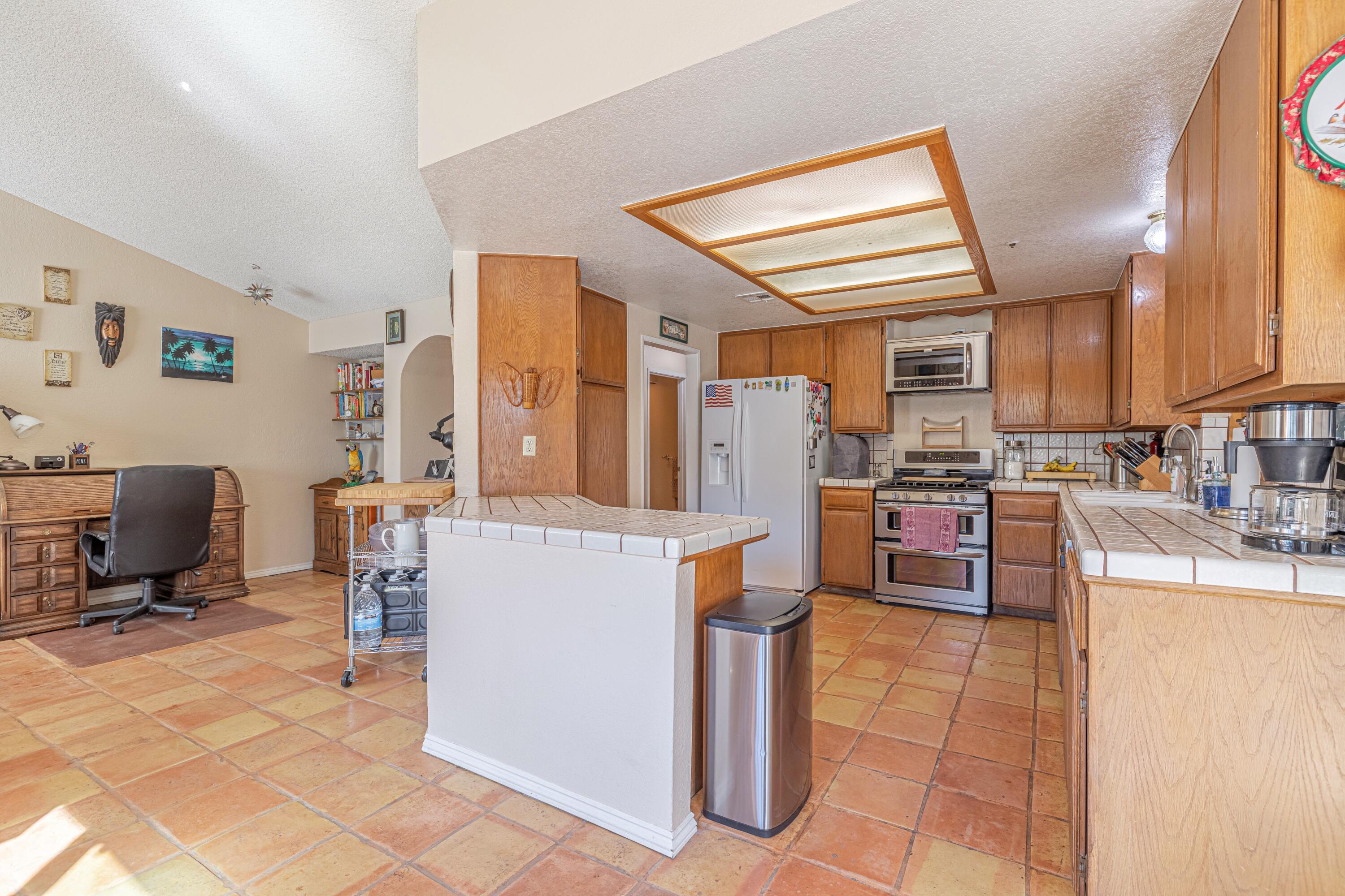 43233 55th Street East Lancaster, CA 93535 - Photo 12 of 46 a living room with stainless steel appliances kitchen island granite countertop furniture and a kitchen view