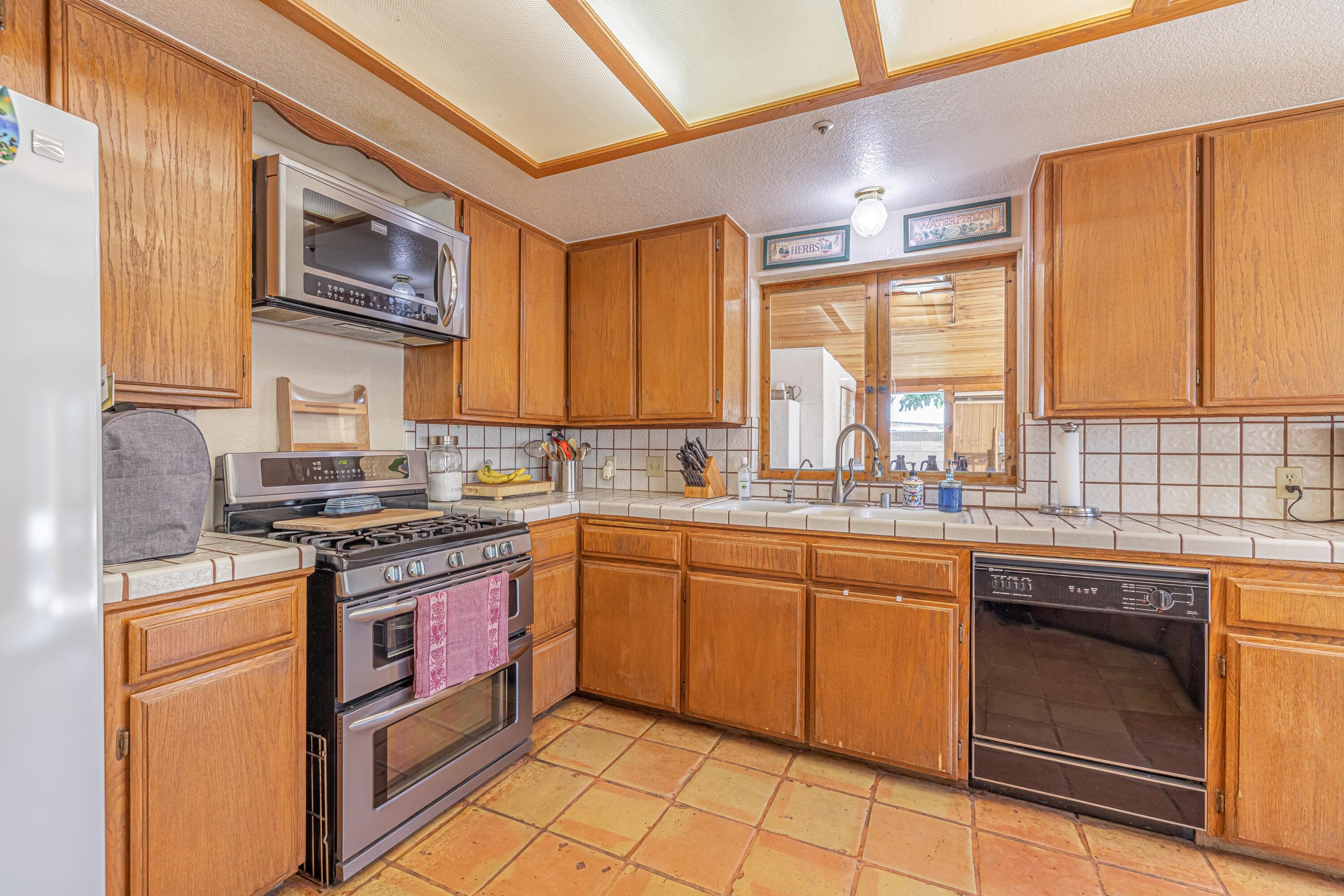 43233 55th Street East Lancaster, CA 93535 - Photo 15 of 46 a kitchen with stainless steel appliances granite countertop a stove sink and cabinets