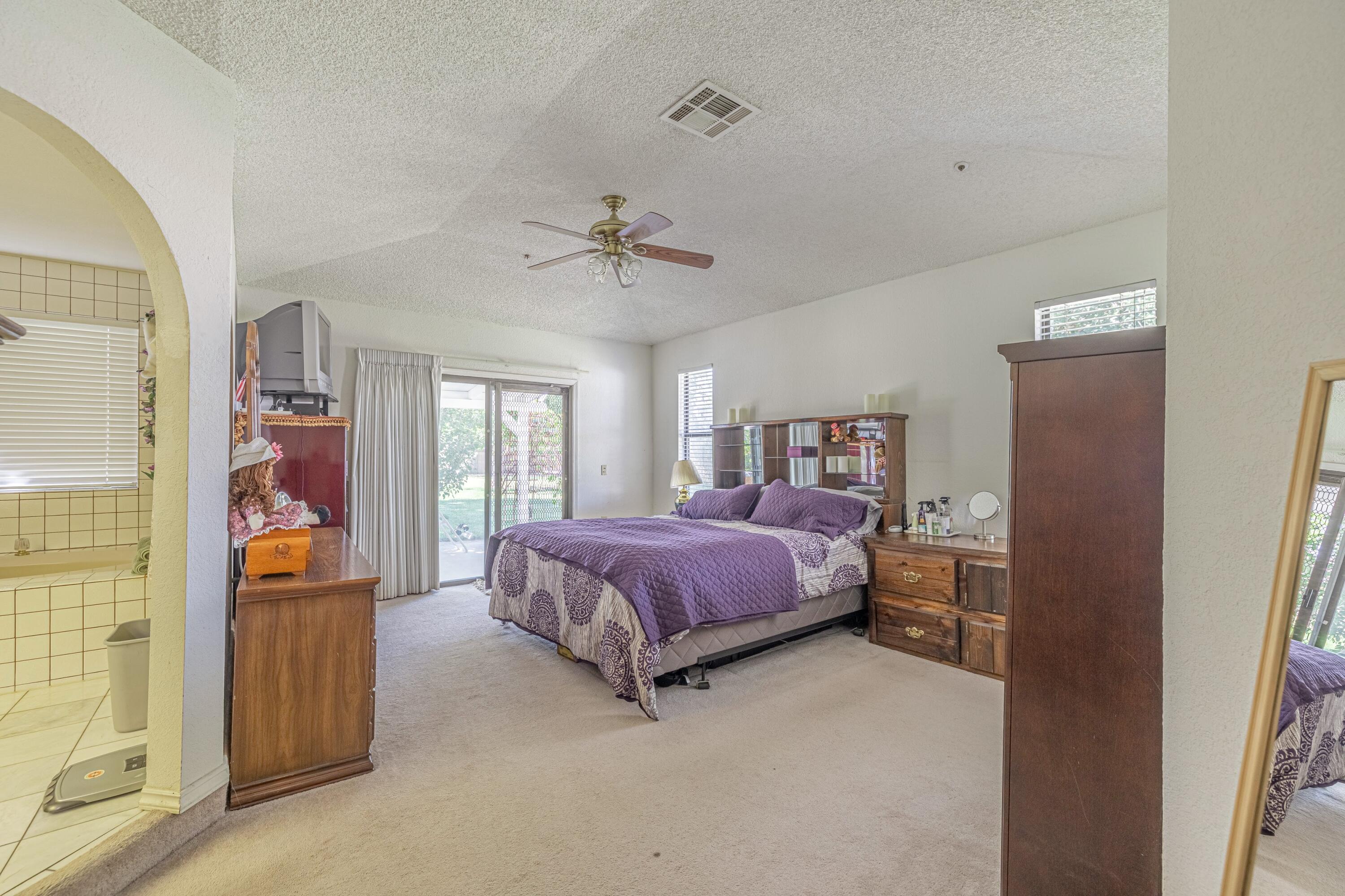 43233 55th Street East Lancaster, CA 93535 - Photo 18 of 46 a spacious bedroom with a bed and a walk in closet