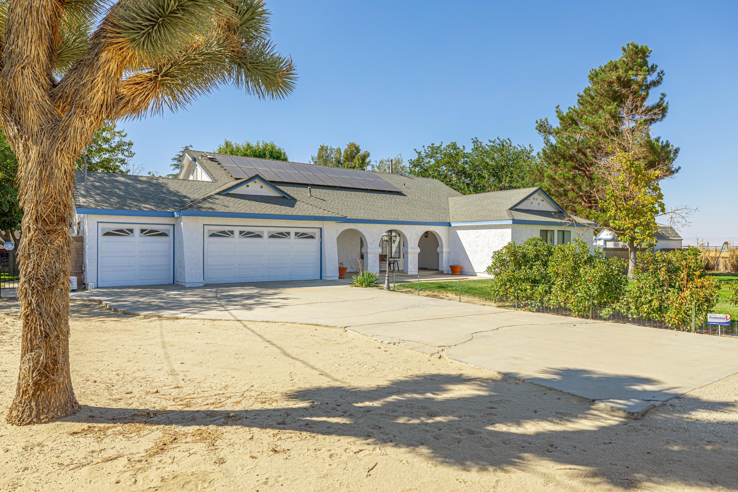 43233 55th Street East Lancaster, CA 93535 - Photo 3 of 46 a front view of a house with a yard and garage