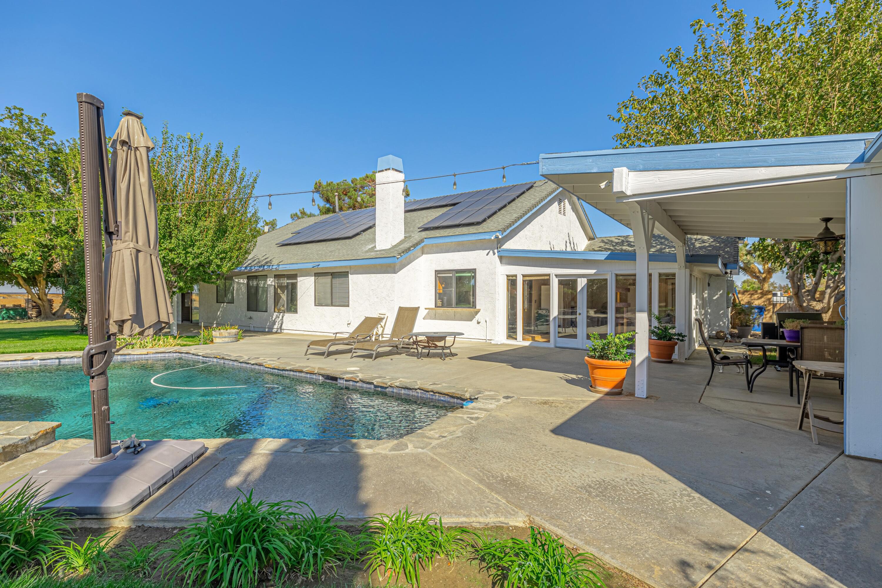 43233 55th Street East Lancaster, CA 93535 - Photo 36 of 46 a front view of a house with swimming pool having outdoor seating