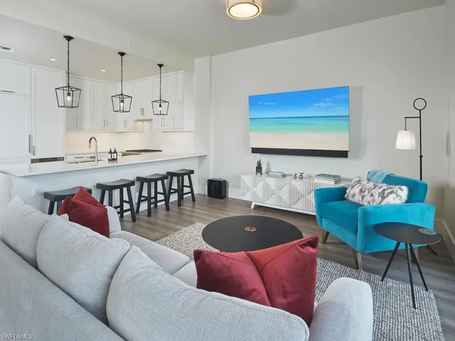 a living room with furniture kitchen view and a chandelier