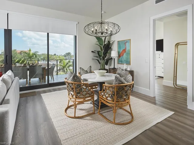 a dining room with wooden floor a chandelier a glass table and chairs