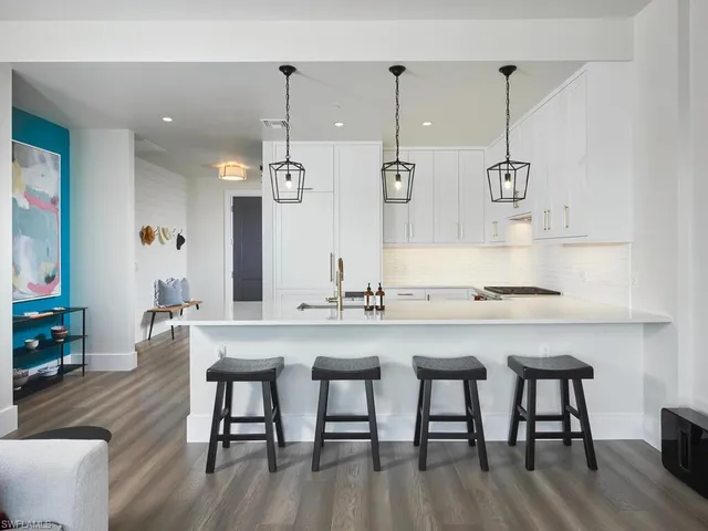 a kitchen with granite countertop white cabinets and chairs