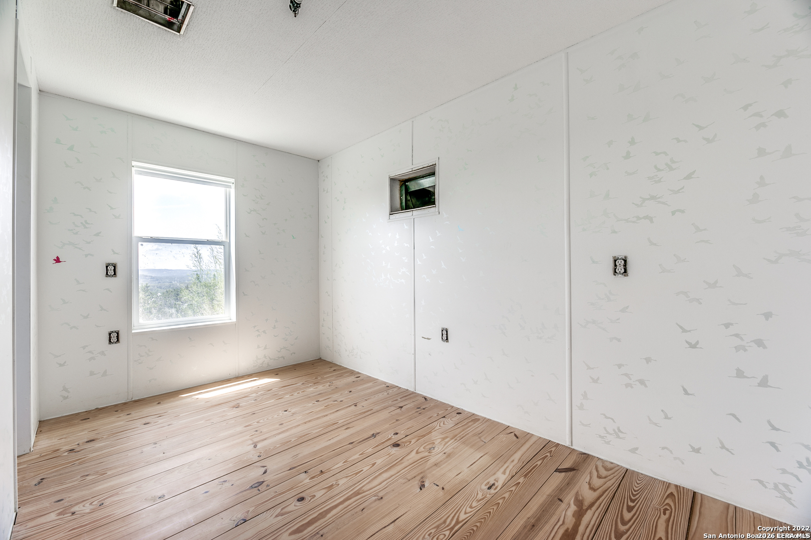 2844 Hidden Valley Road Pipe Creek, TX 78063 - Photo 18 of 30 a view of an empty room with wooden floor and a window