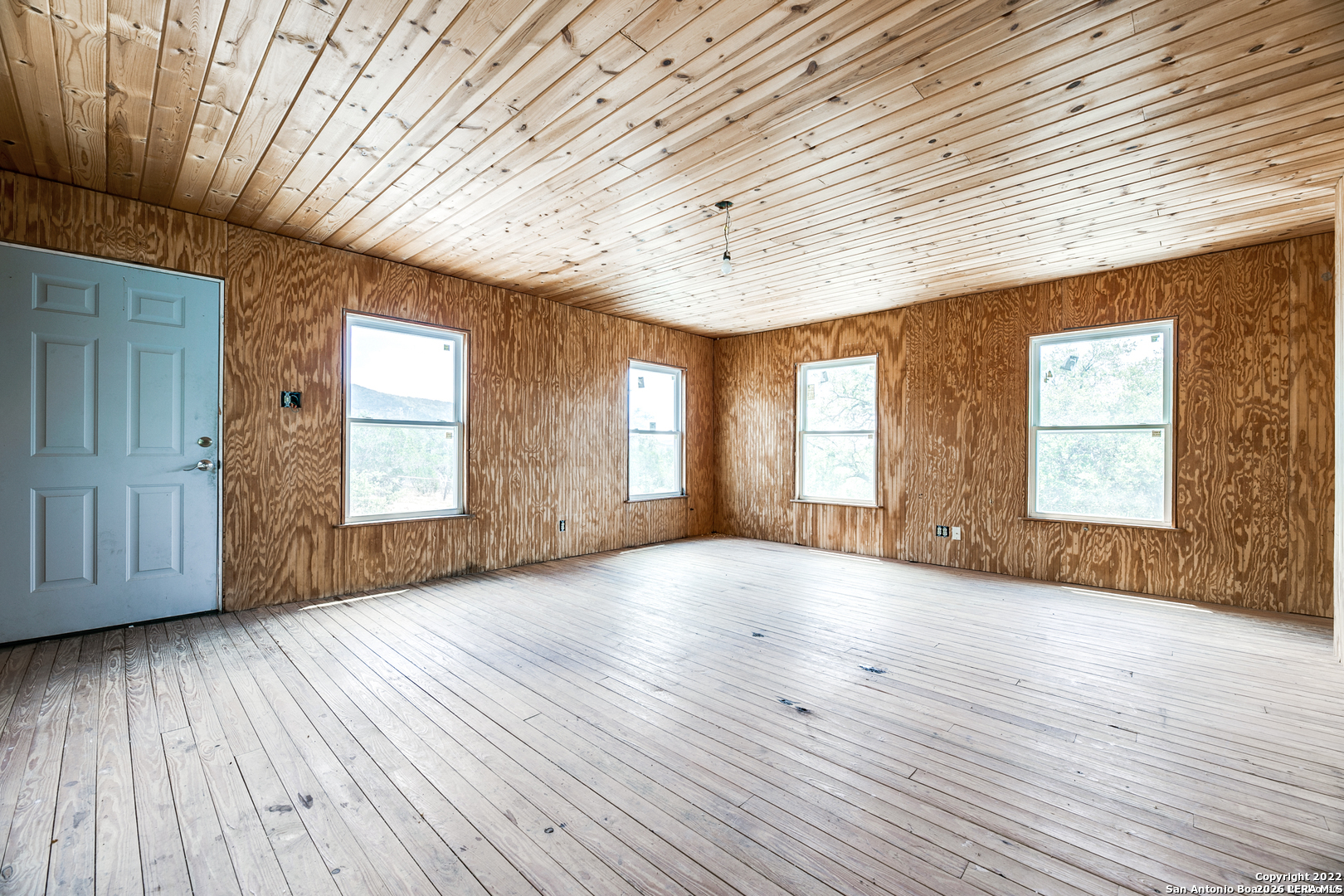 2844 Hidden Valley Road Pipe Creek, TX 78063 - Photo 8 of 30 an empty room with wooden floor and windows