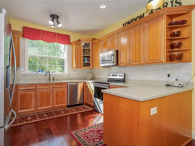 a kitchen with stainless steel appliances granite countertop a sink stove and cabinets