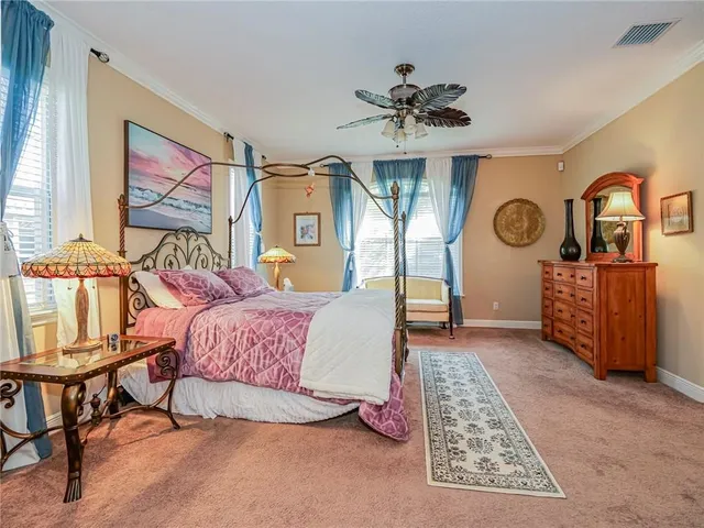 a spacious bedroom with a bed a dresser and next to a window