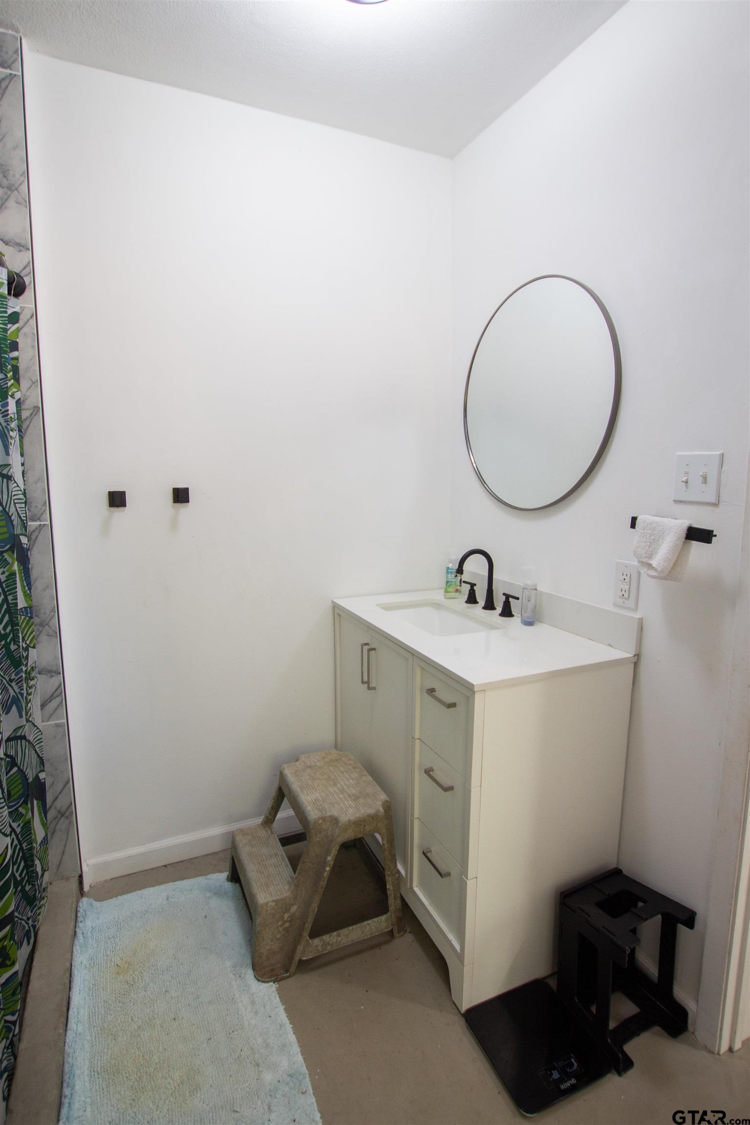 2942 Medlin Road Gilmer, TX 75645 - Photo 16 of 30 a bathroom with a sink mirror and vanity