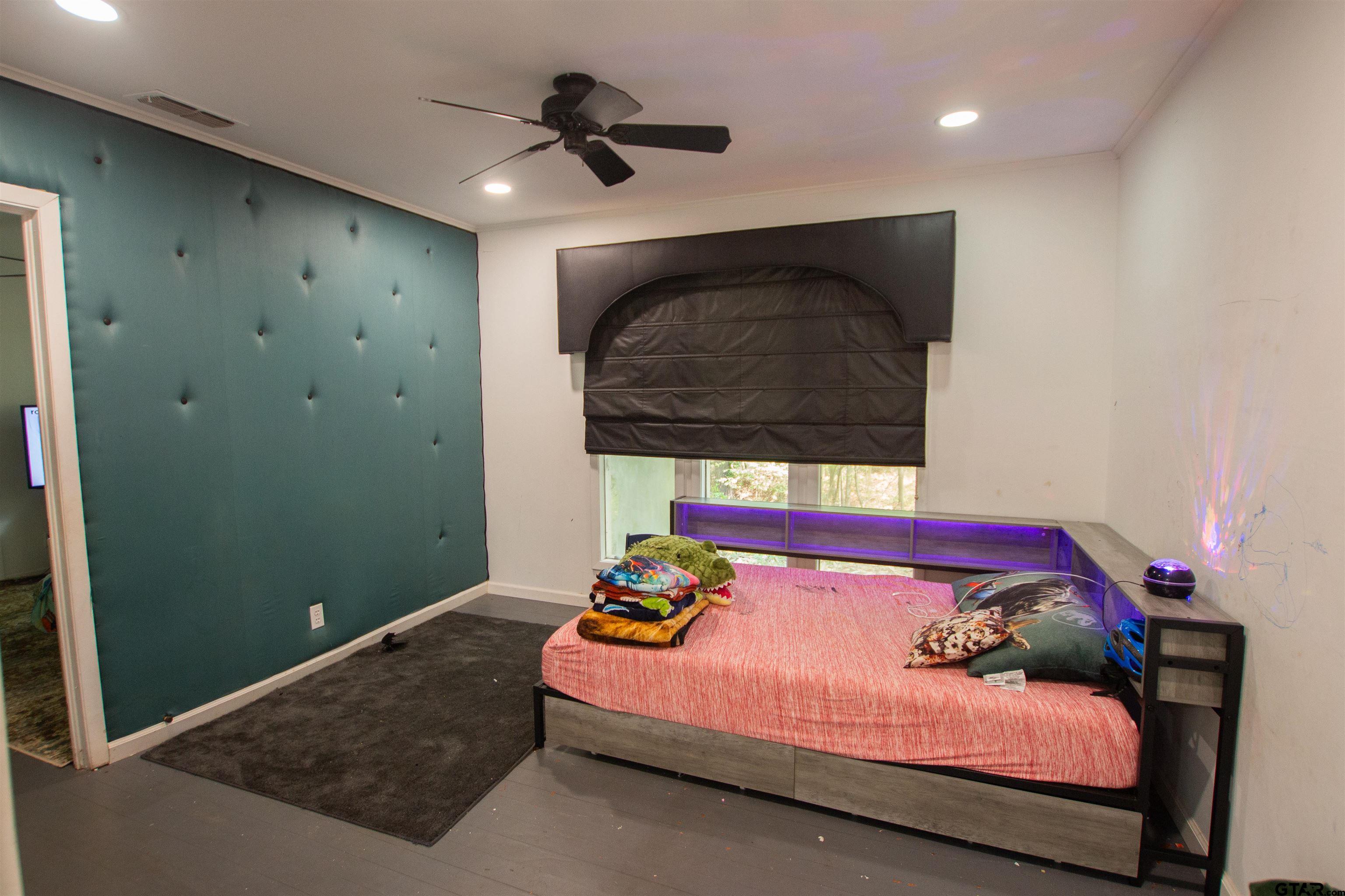 2942 Medlin Road Gilmer, TX 75645 - Photo 17 of 30 a bedroom with a bed and a painting on the wall