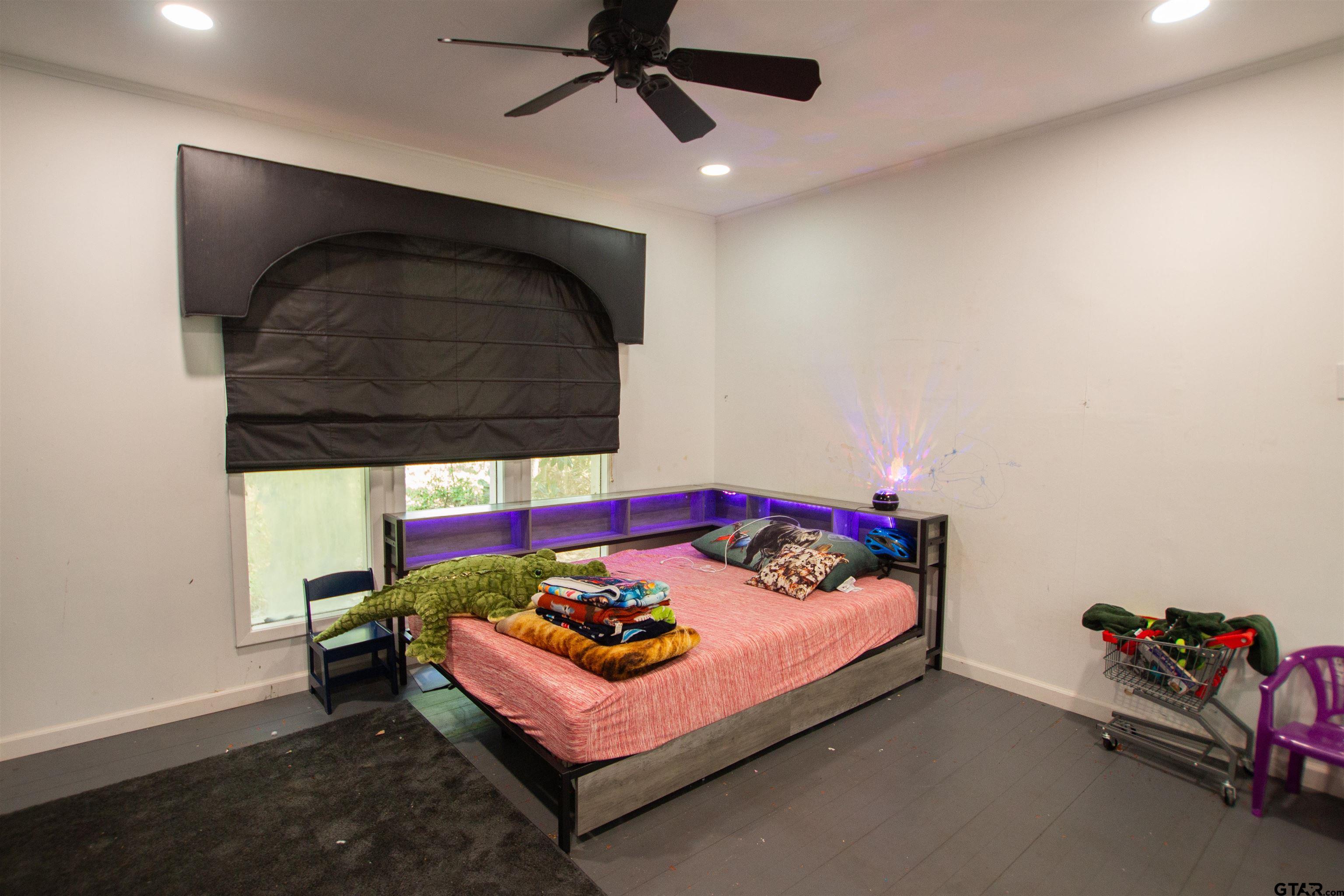 2942 Medlin Road Gilmer, TX 75645 - Photo 18 of 30 a bedroom with a bed and a ceiling fan