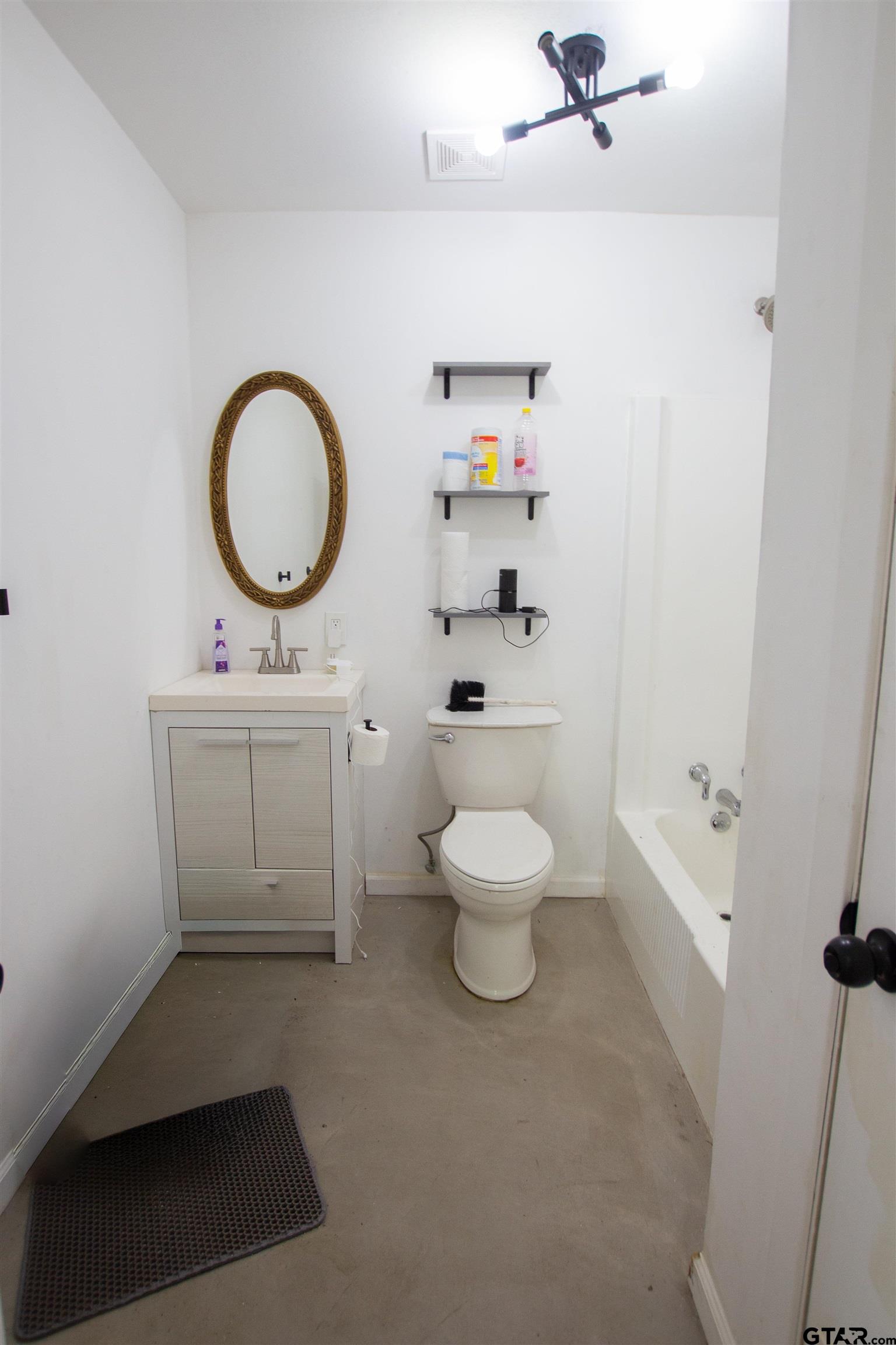 2942 Medlin Road Gilmer, TX 75645 - Photo 20 of 30 a bathroom with a toilet a sink a mirror and vanity